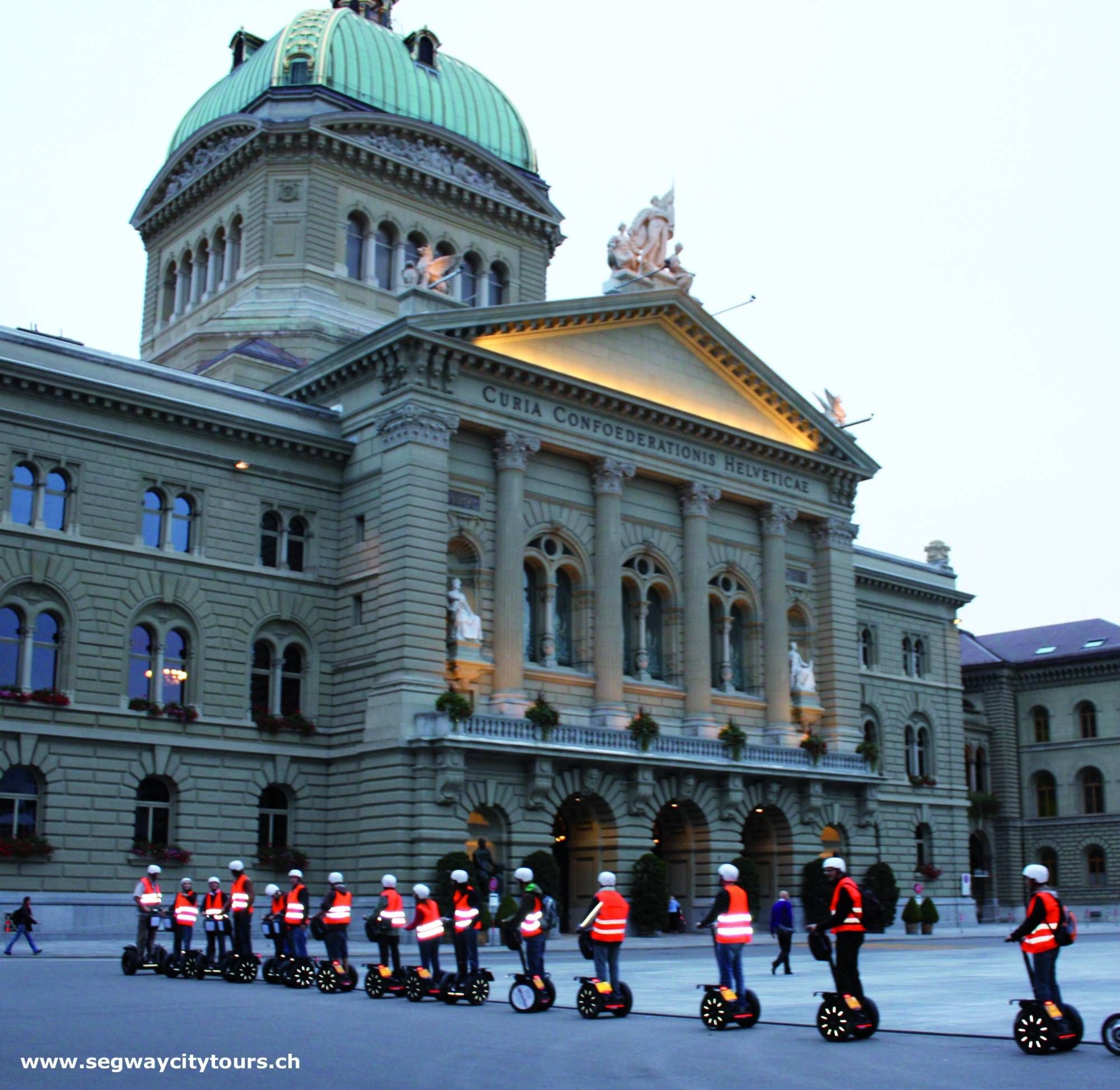 Segway Tour am Bundeshaus in Bern mit steilem Dach und Skulpturen.