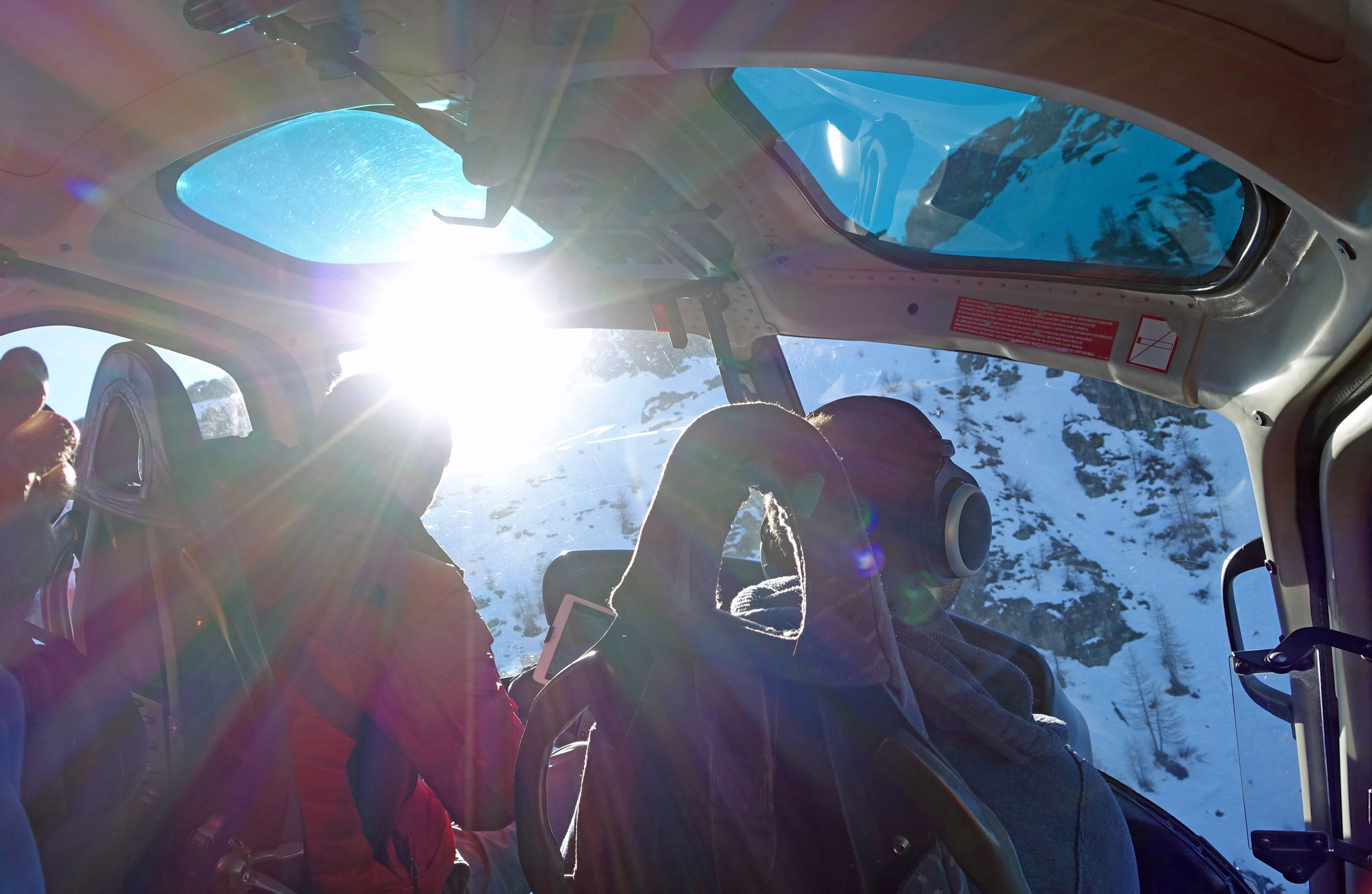 Helikoptertillflygning över Alperna, passagerare i helikoptern, snötäckta berg