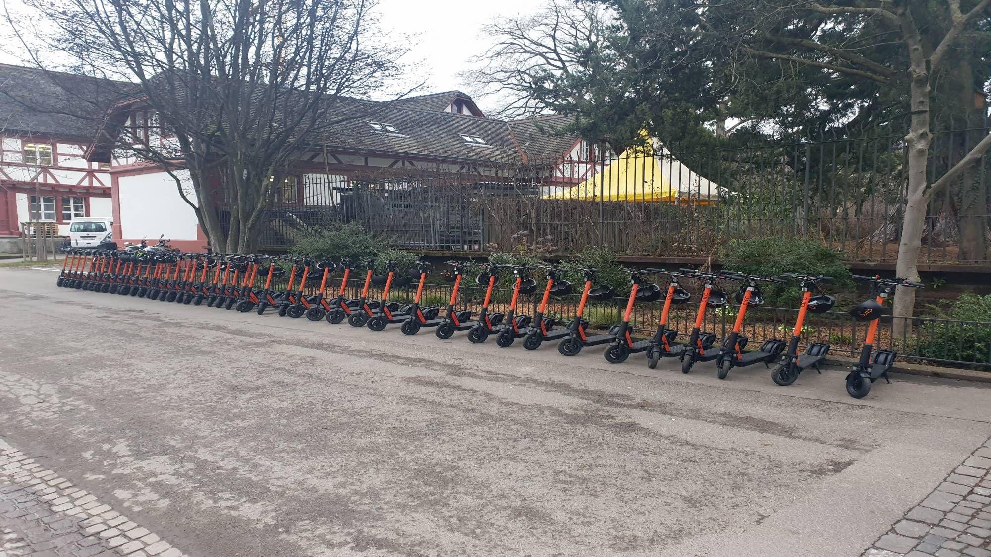 e-Scooter in Basel, aufgereiht an der Straße, ruhiger Tag, Stadtumgebung