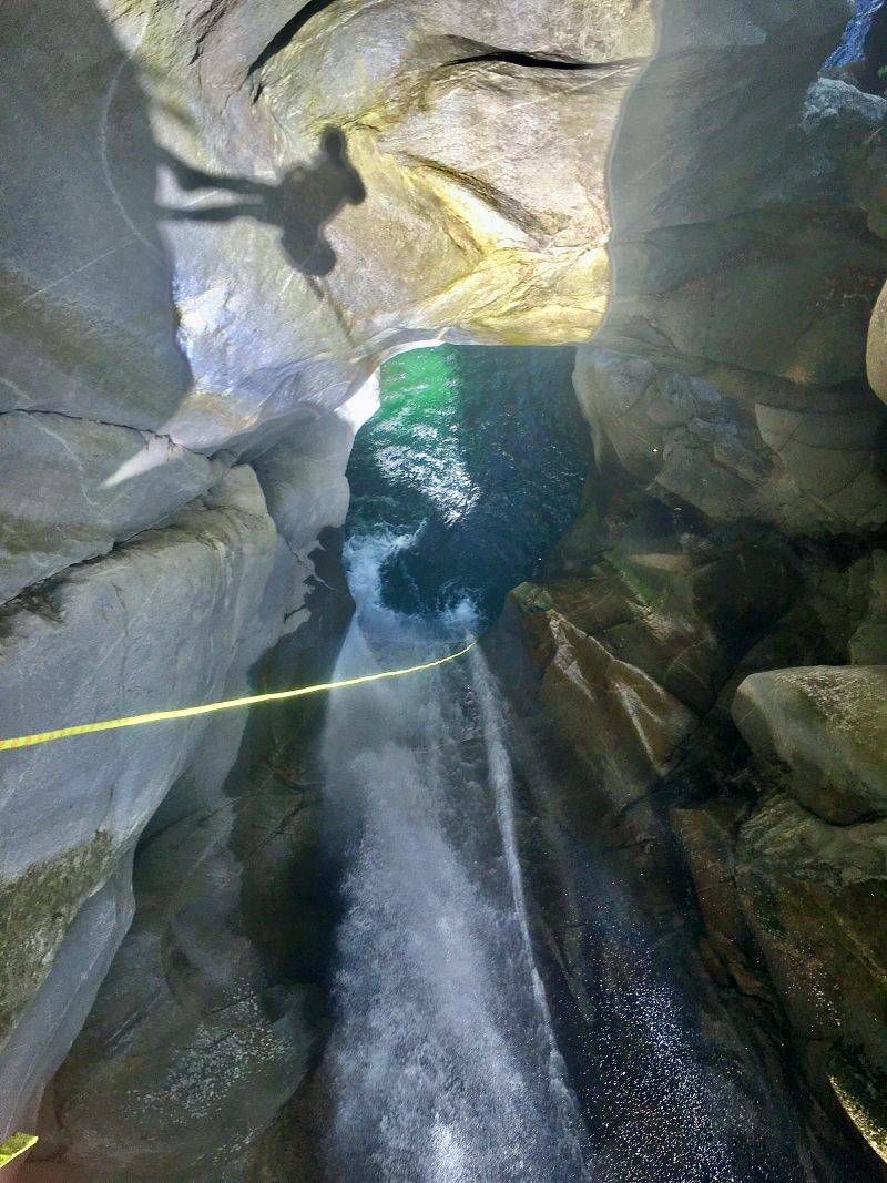 लोड्रिनो कैन्योनिंग: पर्वतारोही क्रिस्टल साफ पानी में कूद रहा है।