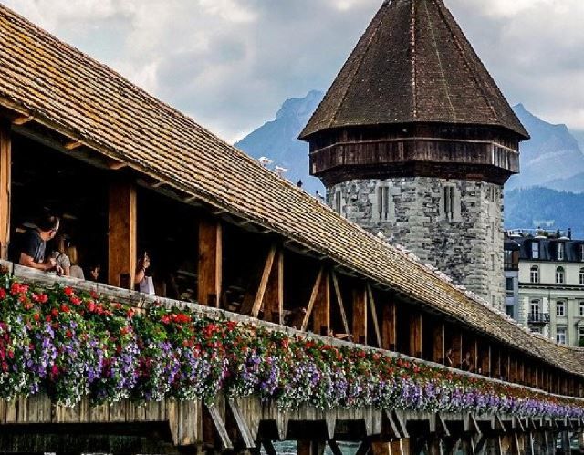 Kapellbrücke Luzern mit bunten Blumen und Turm im Frühling