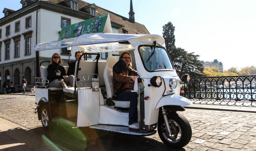 E-Tuk Sightseeing in Zürich, Passagiere genießen die Stadtfahrt am See.