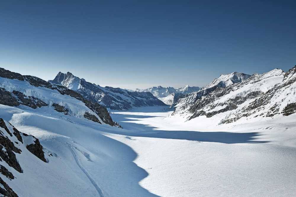 जंगफ्रौजोक पर प्रभावशाली आल्पस दृश्य, बर्फ से ढके पहाड़, स्पष्ट आकाश