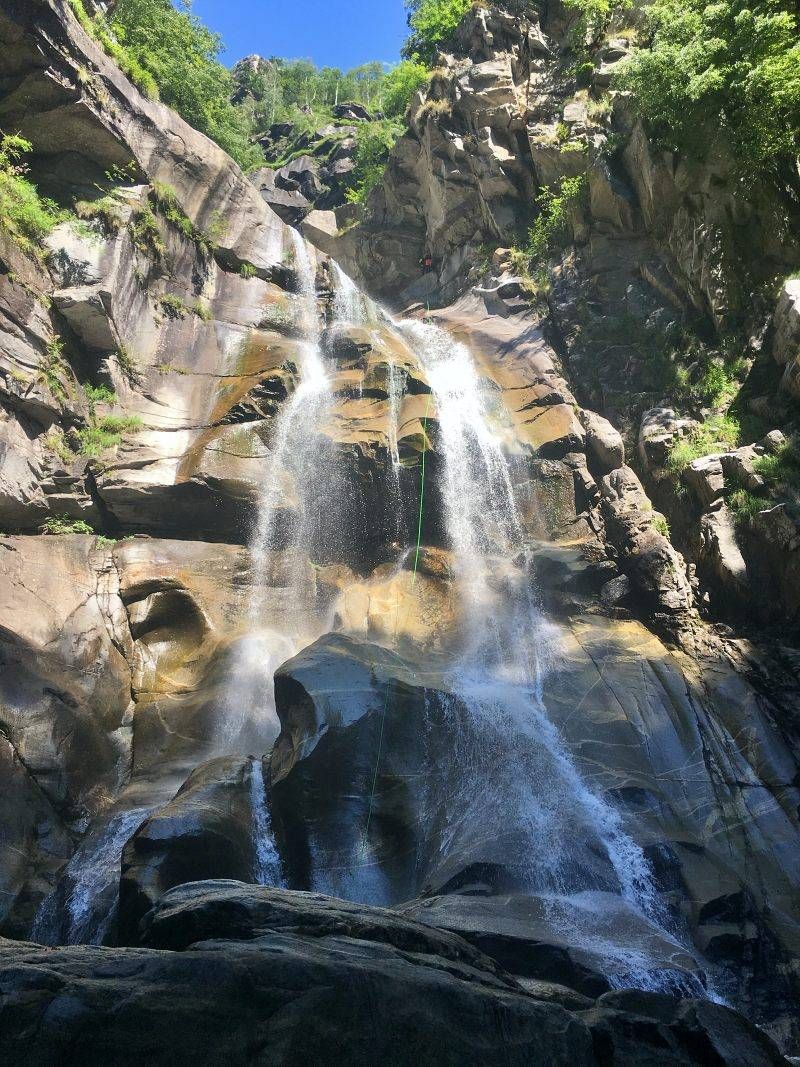 कैनीयनिंग लोड्रिनो जलप्रपात जिसमें चट्टानों के ऊपर गिरता पानी है।