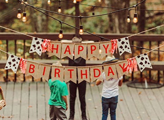 Birthday party with colorful banners and little lights, children celebrating outdoors