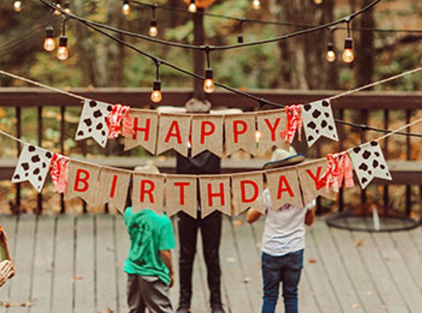 Festa di compleanno con striscioni e luci all'aperto.