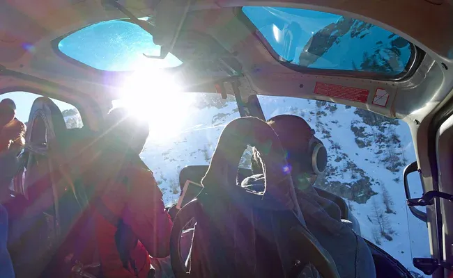 Helicopter tour with a view of the mountains in sunny weather.