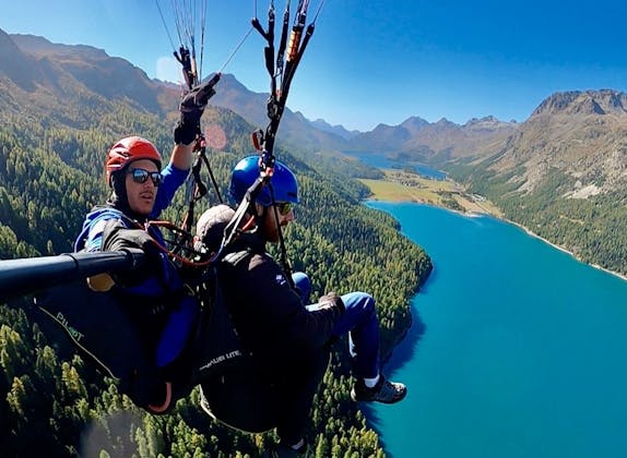 Paragliding im Engadin: Erlebe den Flug über den See und die beeindruckenden Berge.