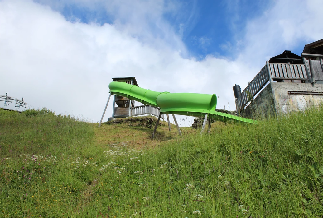 Scivolo per bambini su Tschentenalp con vista sul verde, tempo soleggiato