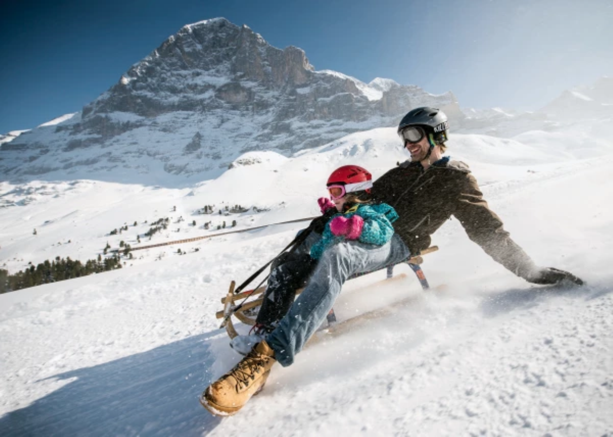 Kälkåkning vid Eiger Run: Kul i snön med barn i vinterlandskapet.