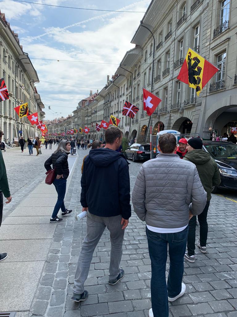Kramgasse: Entdecke die Schokoladen Stadttour in Bern mit vielen Fahnen und einer tollen Atmosphäre.