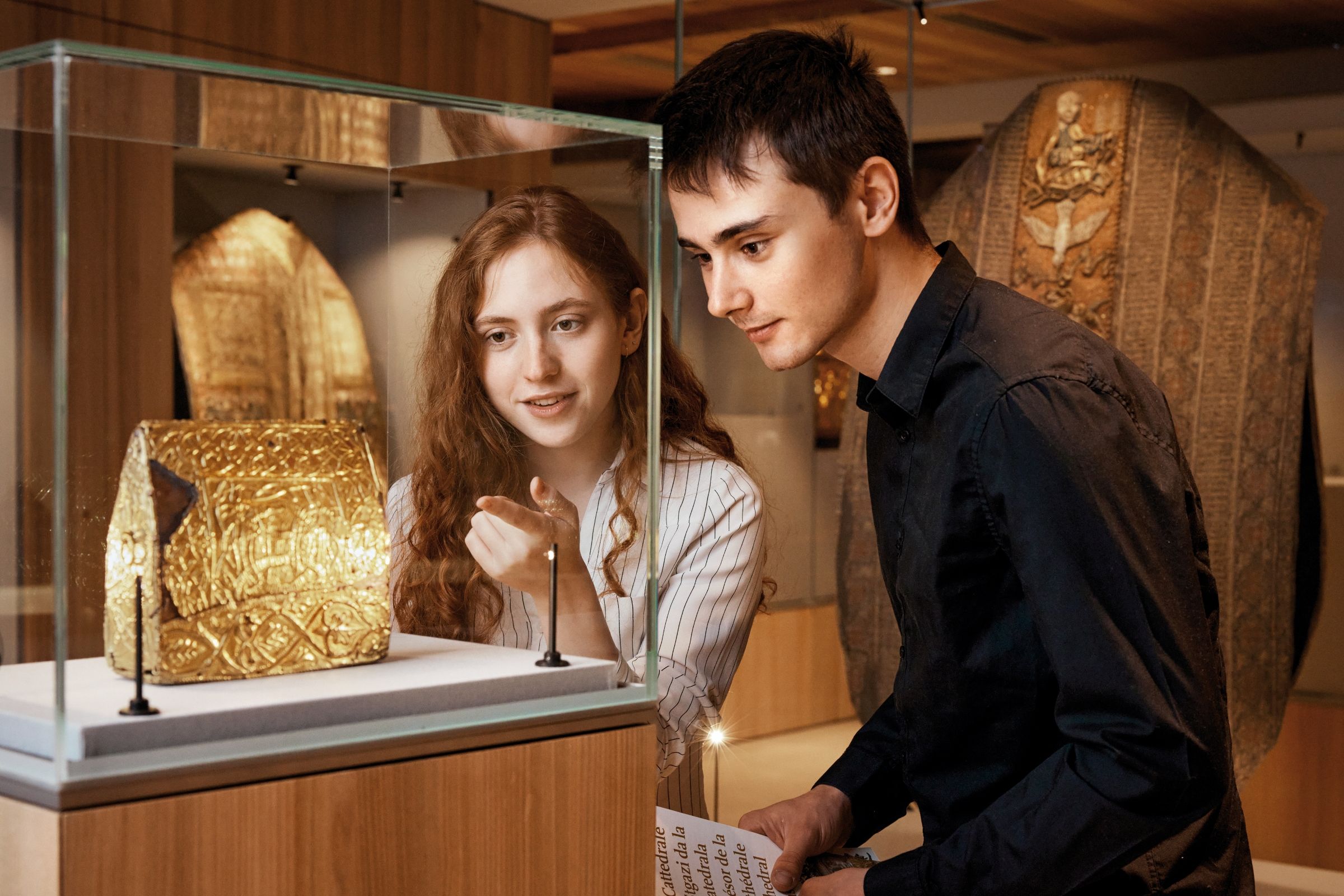 Pengunjung melihat artefak emas di Muzium Harta Dom di Chur.