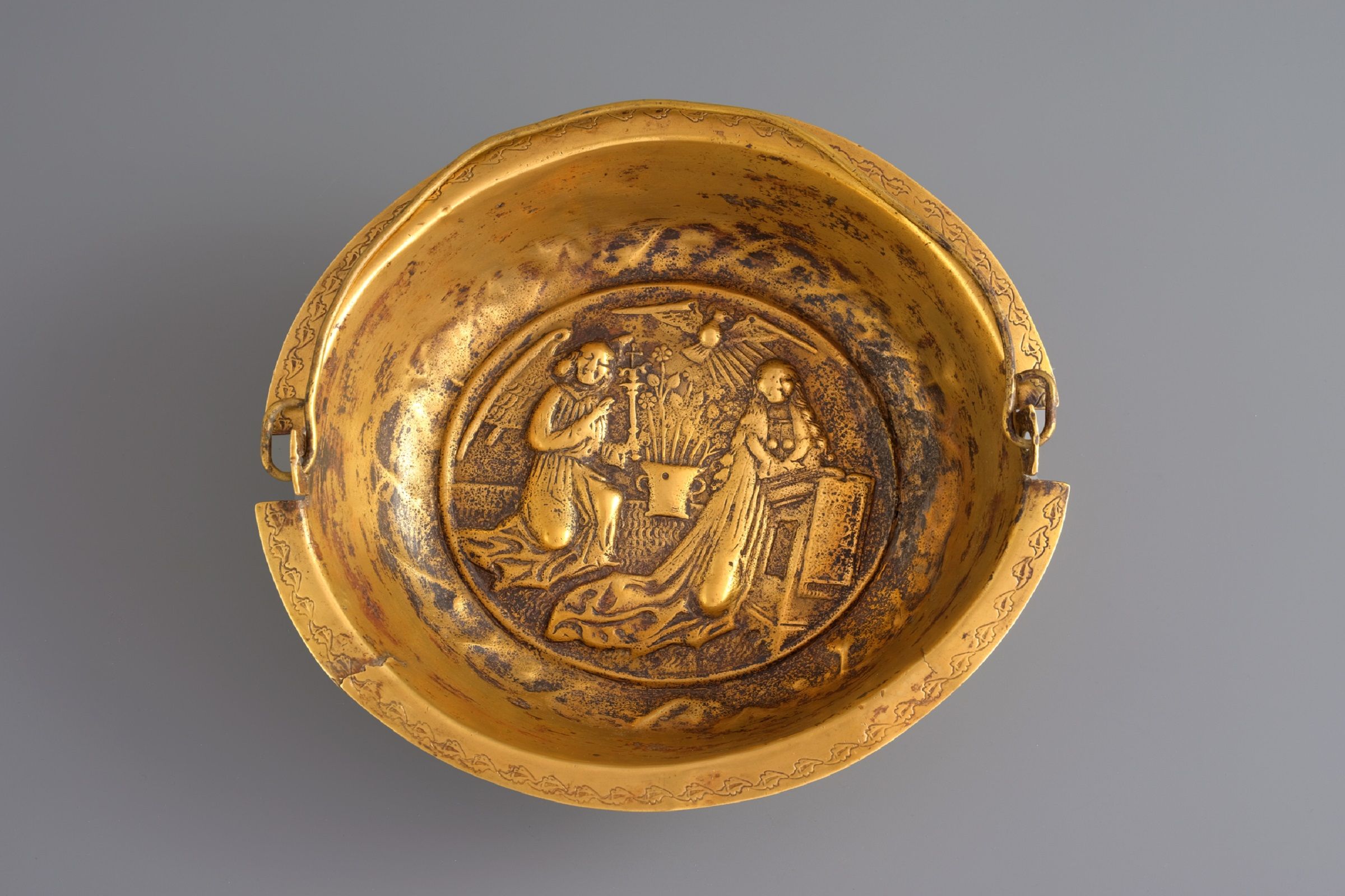 Kout nádoby na posvěcenou vodu v muzeu pokladů katedrály ve Švýcarském Churu s ozdobami a figurkami