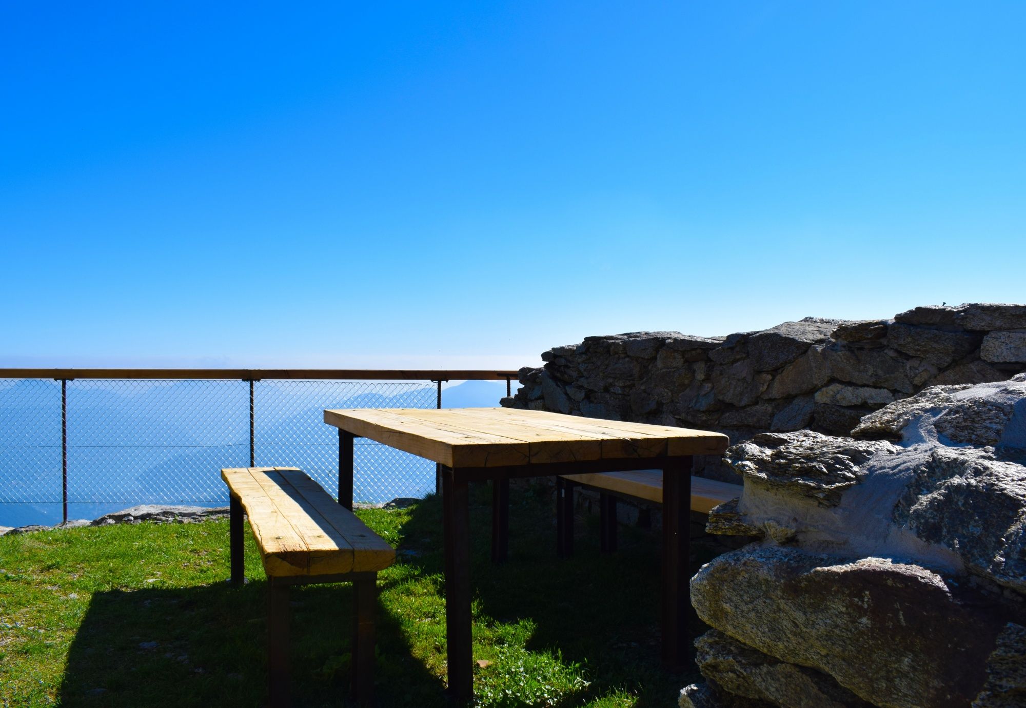 Seilbahn Monte Lema: Genieße das Picknick mit schöner Aussicht auf die Alpenlandschaft.
