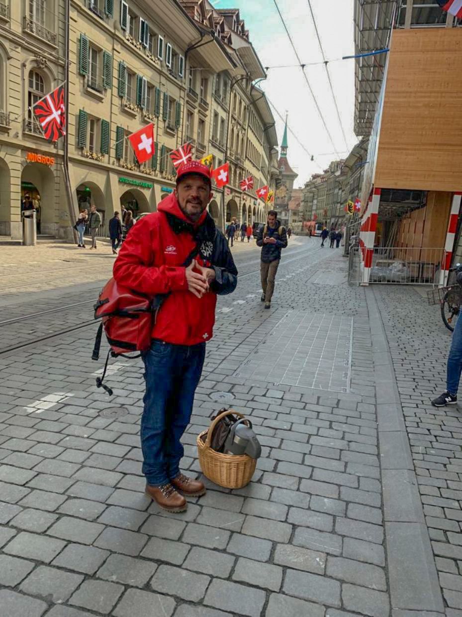 Marktgasse: Genieße die Schokoladentour in Bern mit historischen Gebäuden und Schweizer Flaggen.