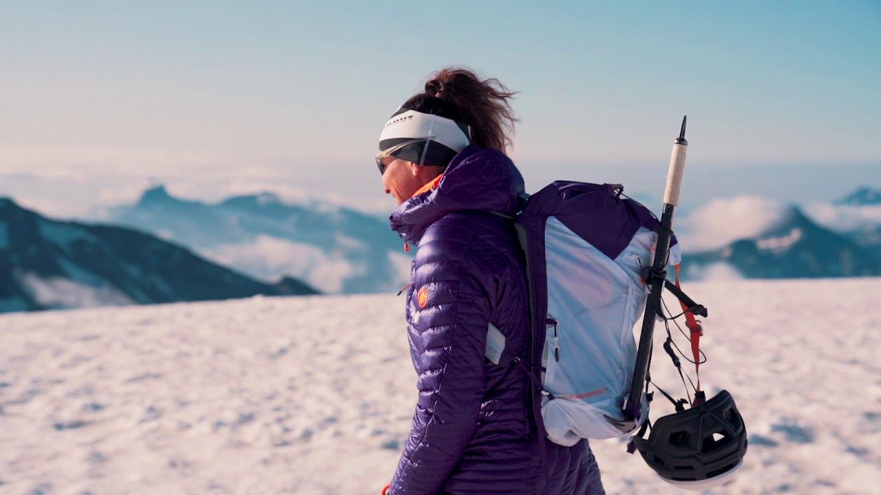 Castor Bergtour: Vrouw met rugzak op besneeuwd top, ideaal voor outdoor-activiteiten en avonturen.