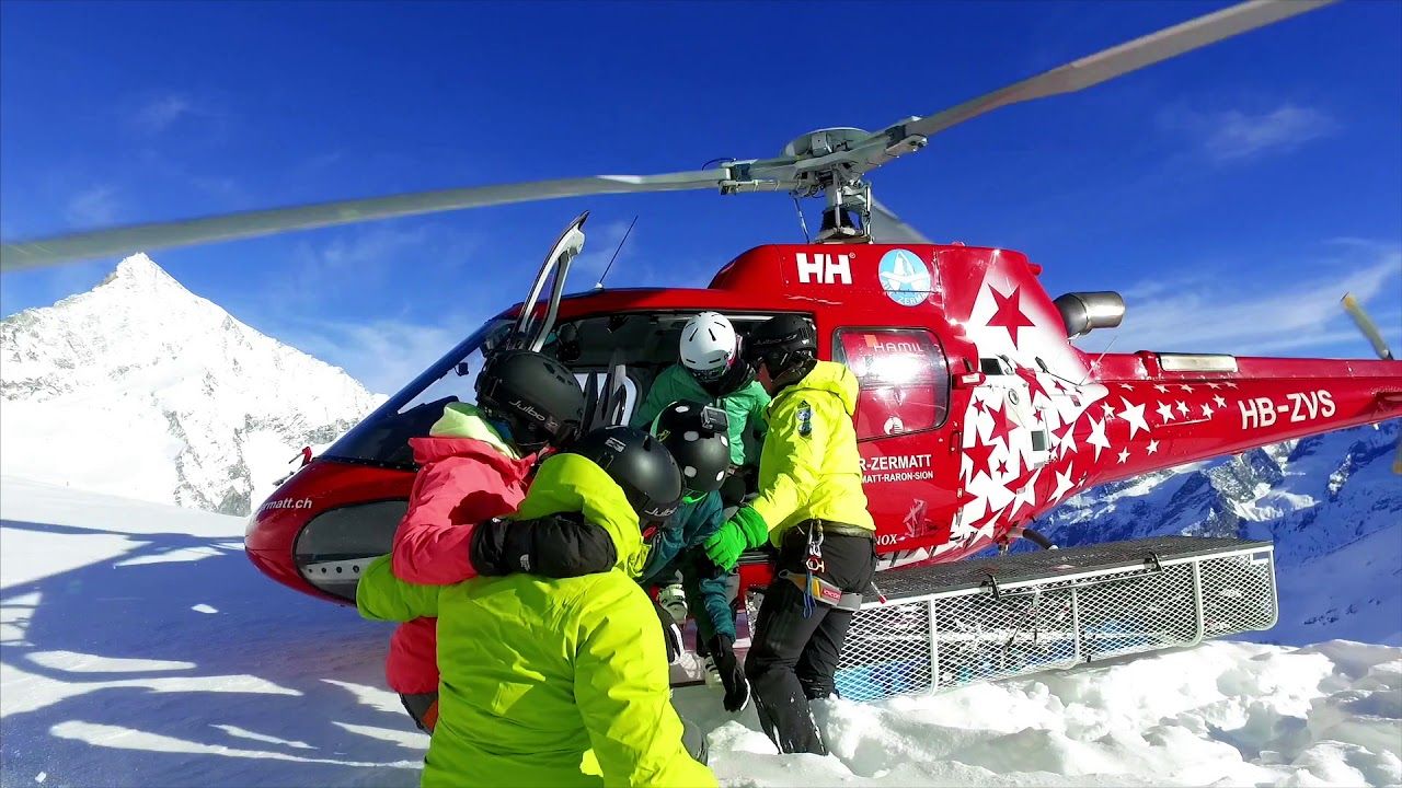 Freeride Snowboard Turun Helikopter di Pegunungan Alpen bersama kelompok di salju.