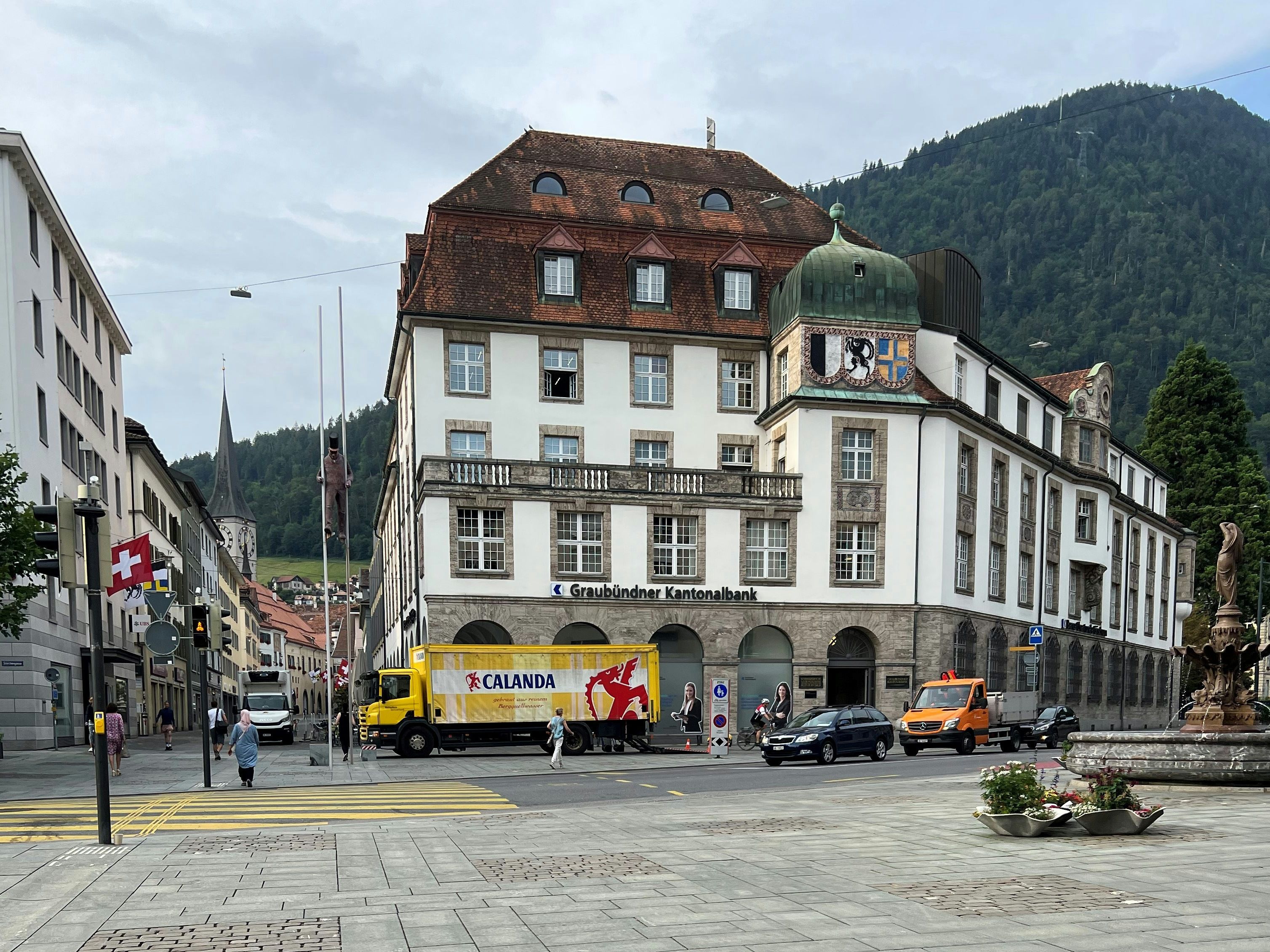 Общий вид города: исторические здания и оживленная улица, полная транспорта, в регионе, идеально подходящая для прогулок.
