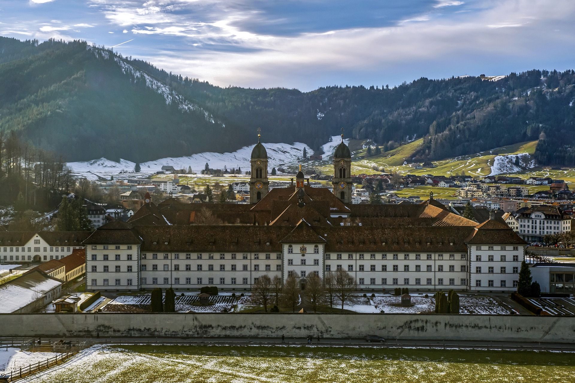 Einsiedeln kloster: imponerande arkitektur på vintern med snötäckt terräng och berg.