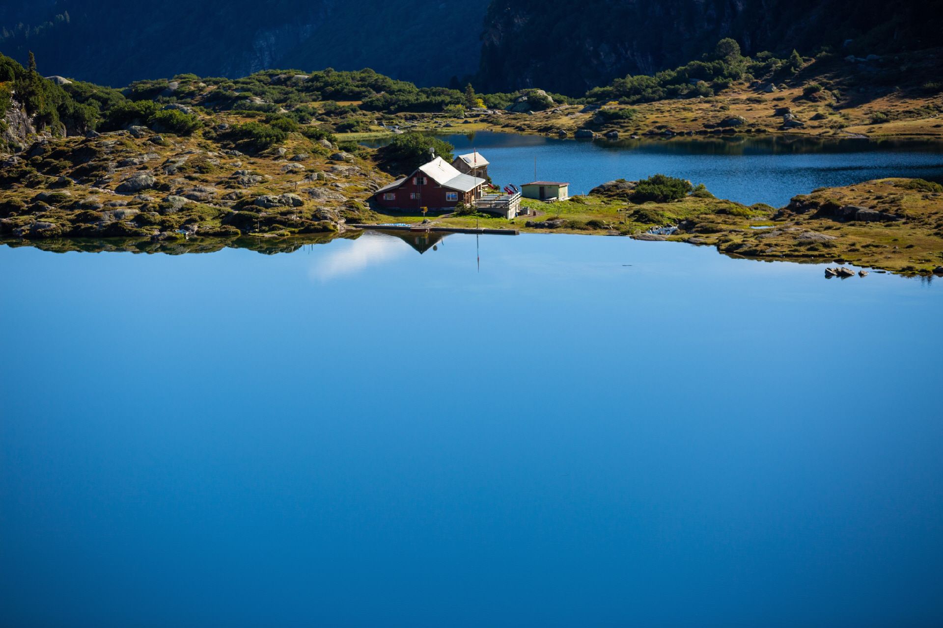 Jalan Penyelidikan Geopark Sardona dengan pemandangan danau yang tenang serta pemandangan gunung