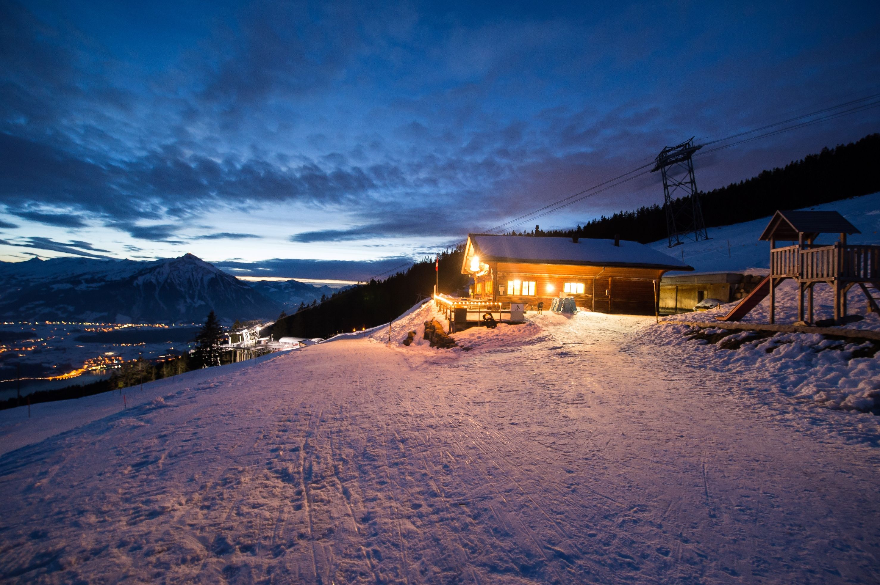 Niederhorn: Zimní večer s sáňkováním, sněhem pokrytými sjezdovkami a oblohou plnou mraků.