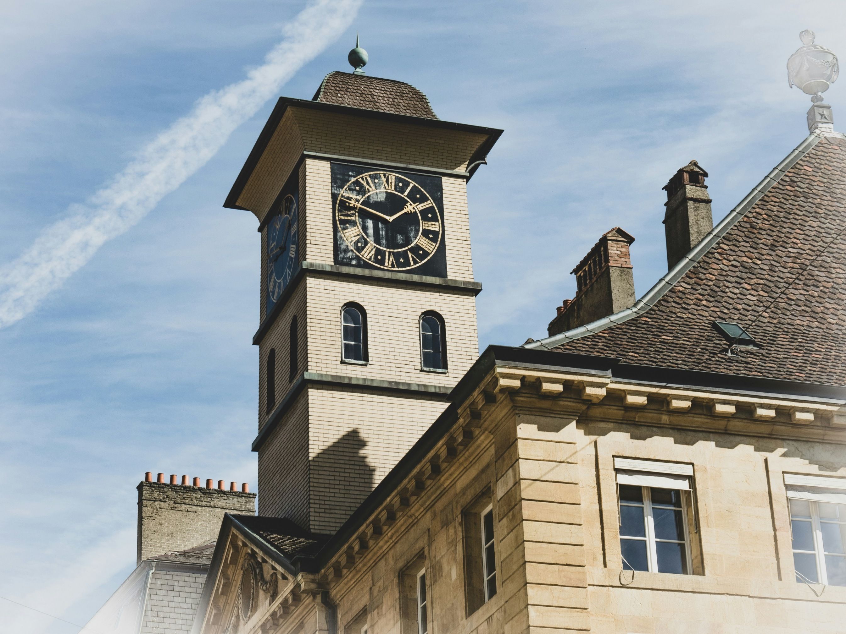 نيوشاتل: برج ساعة تاريخي في المدينة تحت سماء زرقاء، معلم سياحي، عمارة، سحب.