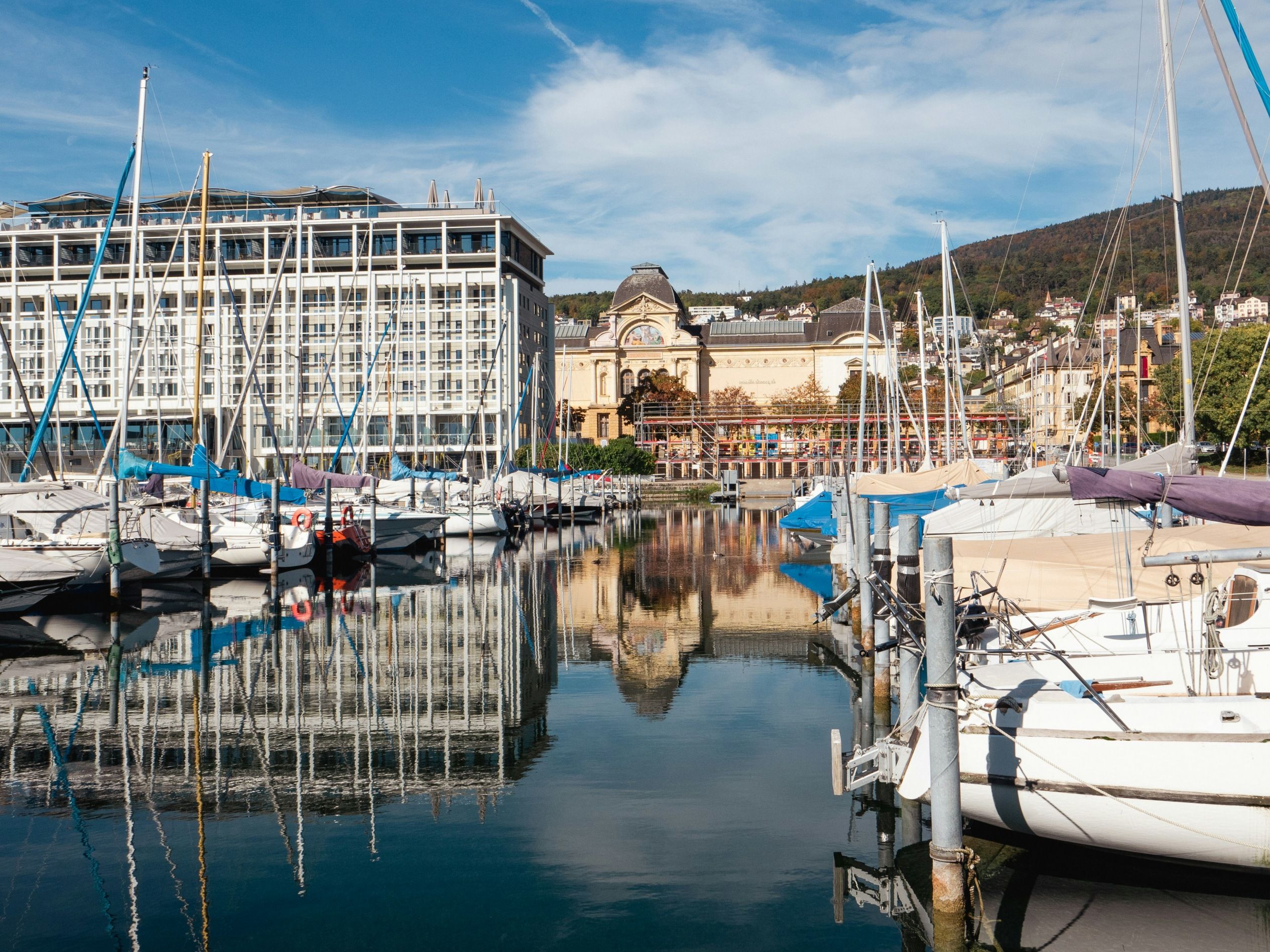 Neuchâtel: pelabuhan yang menawan dengan bot dan permukaan air yang memantulkan cahaya di musim panas