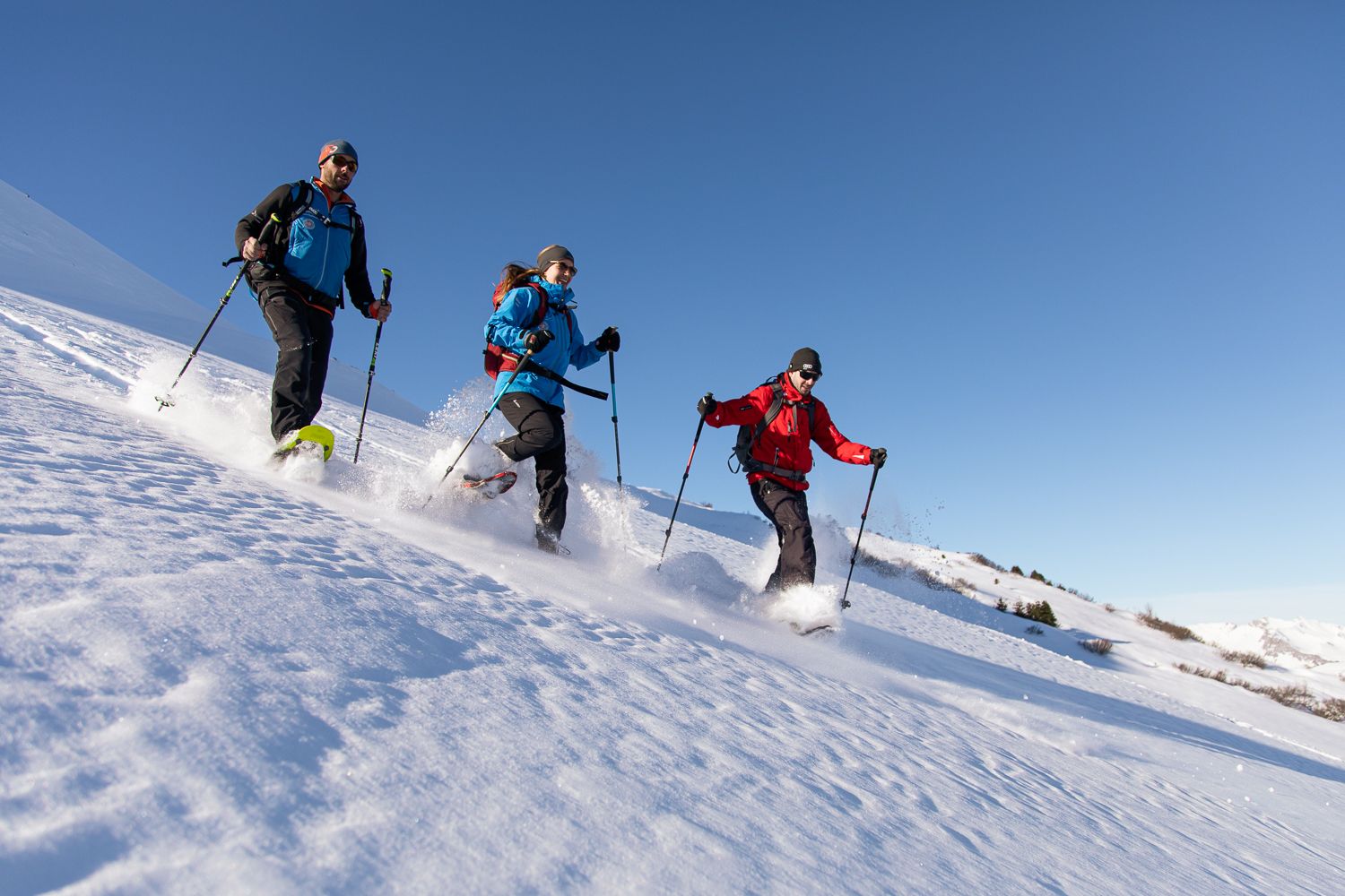 Ciaspolare a St. Antönien, paesaggio innevato, cielo soleggiato, escursionisti attivi