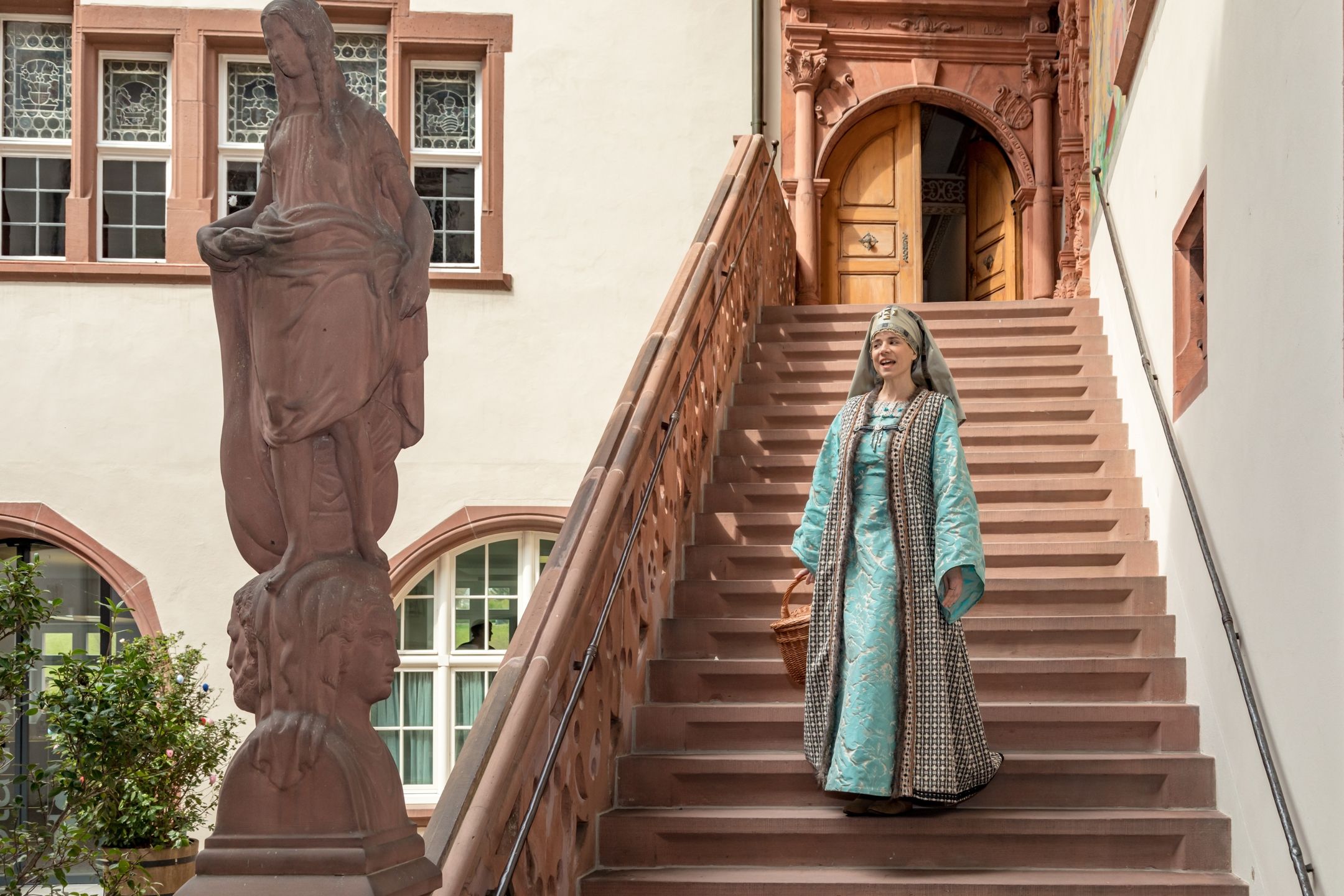Agnes von Rheinfelden i traditionell klädsel går nerför trappan.