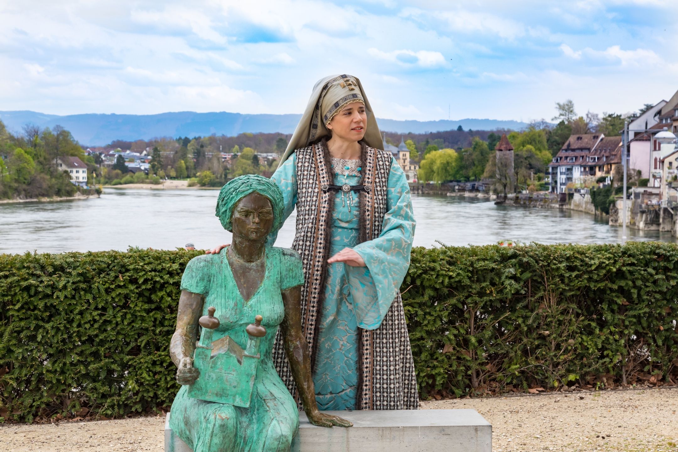 Kvinna i historisk klädsel berättar historier vid Rhenfloden strand