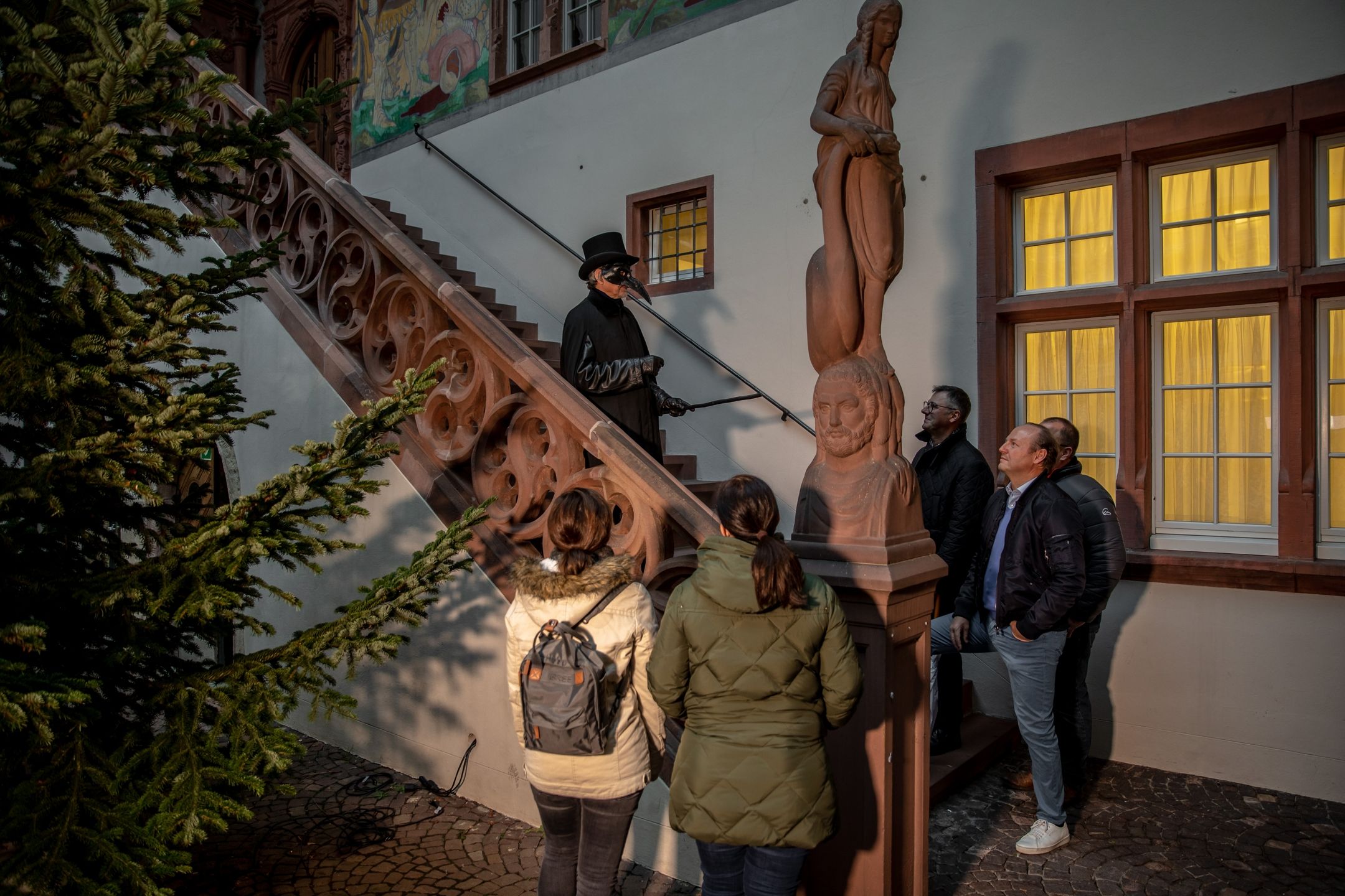 Night city tour Rheinfelden, group admires the town hall
