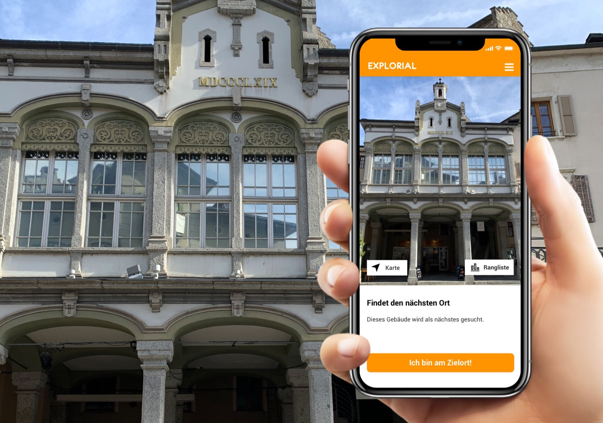 Gra w podchody ze smartfonem przy historycznym budynku w Sionie, odkryj miasto z interaktywnymi elementami.