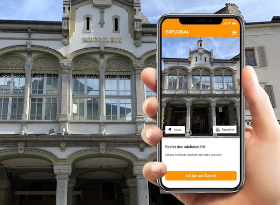 Schnitzeljagd: Smartphone zeigt das historische Gebäude in Sion mit interaktiven Optionen.