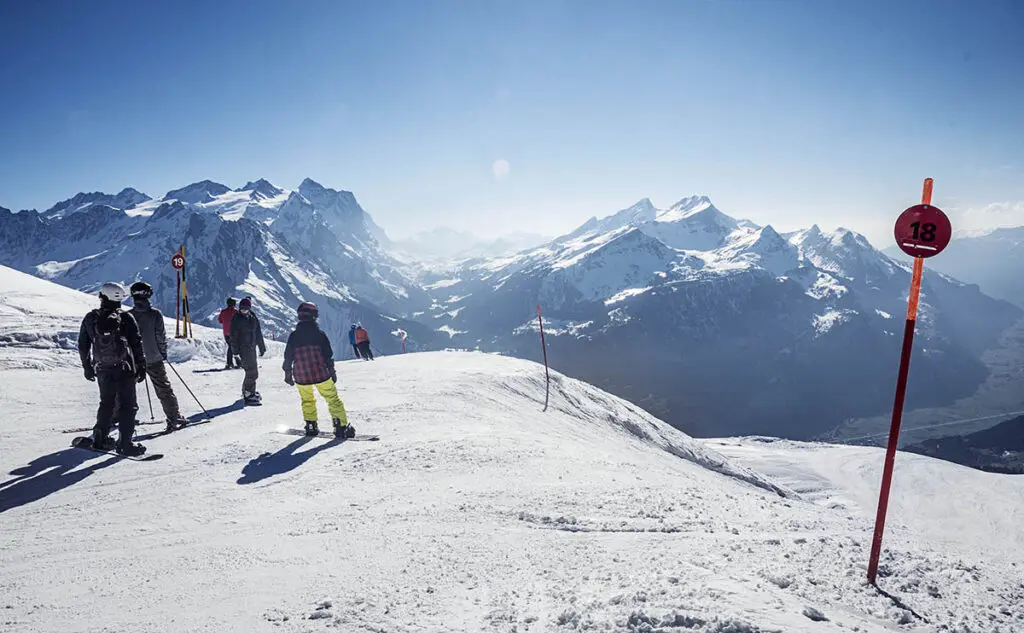 겨울에 스키를 타는 사람들과 인상적인 산 풍경이 있는 스키 학교로, 모험을 위한 완벽한 조건입니다.