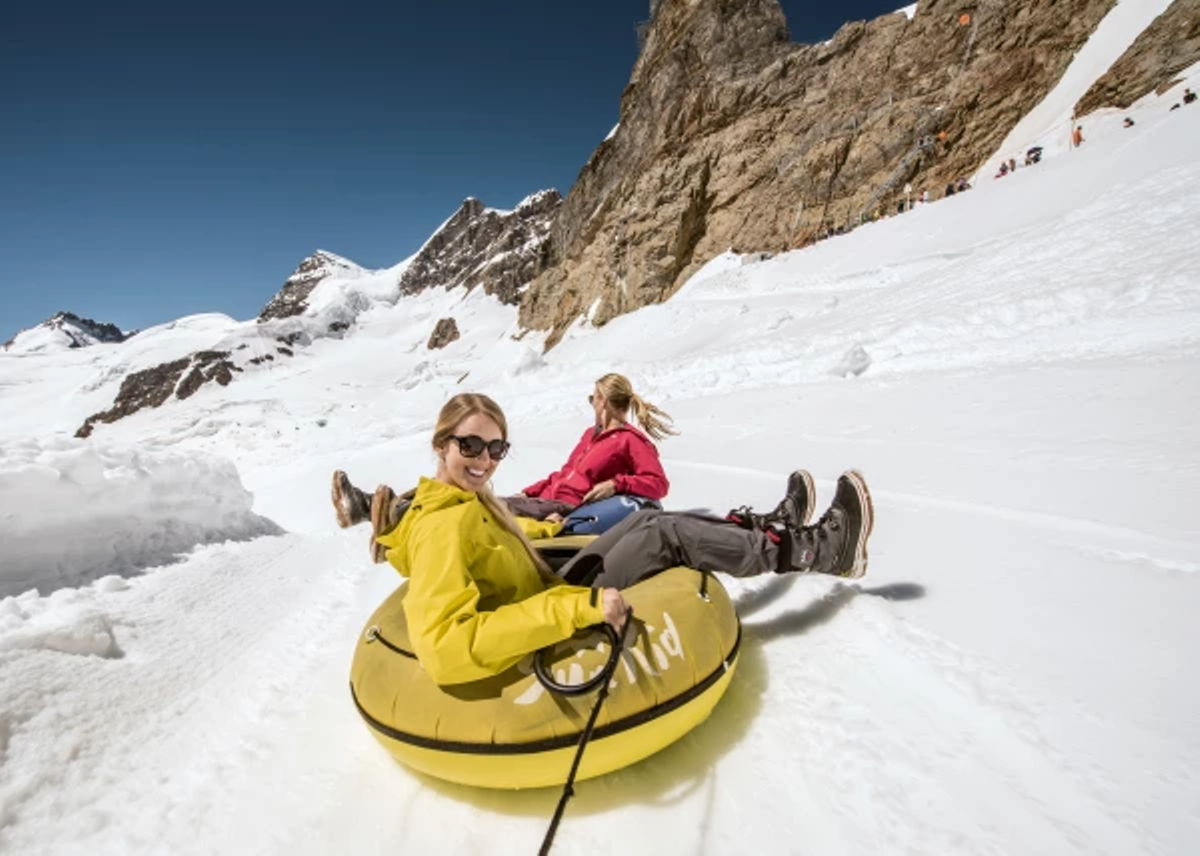 Sledding en Jungfraujoch en invierno con amigos y una maravillosa panorámica de montañas.