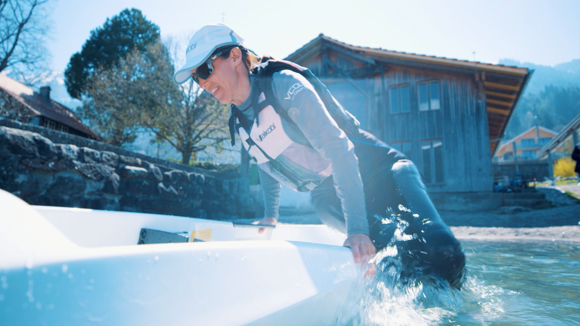 카약 대여: 여성이 물가에서 카약에 타고 있다. 화창한 날, 조용한 환경.