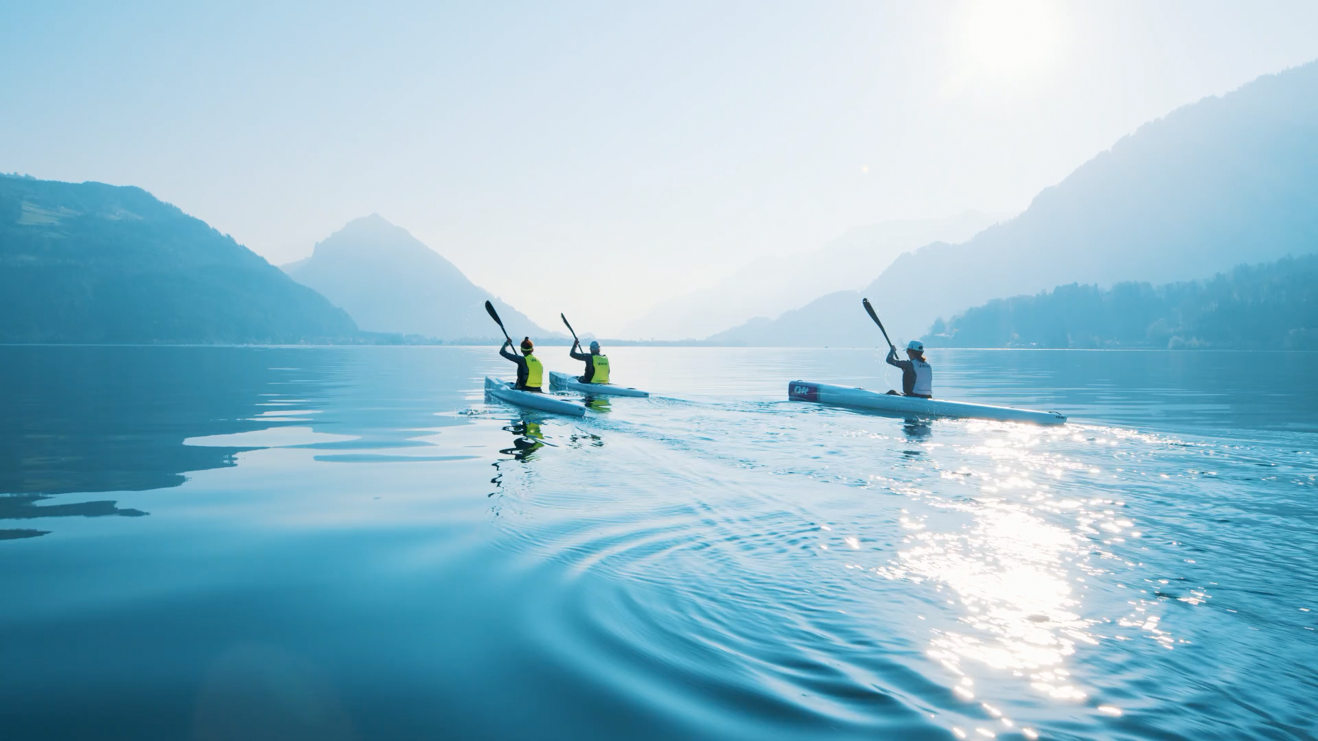 ボーデン湖でのサーフスキー・カヤック、アスリートたちが滑らかな水面でパドルを漕ぎ、視界はクリア