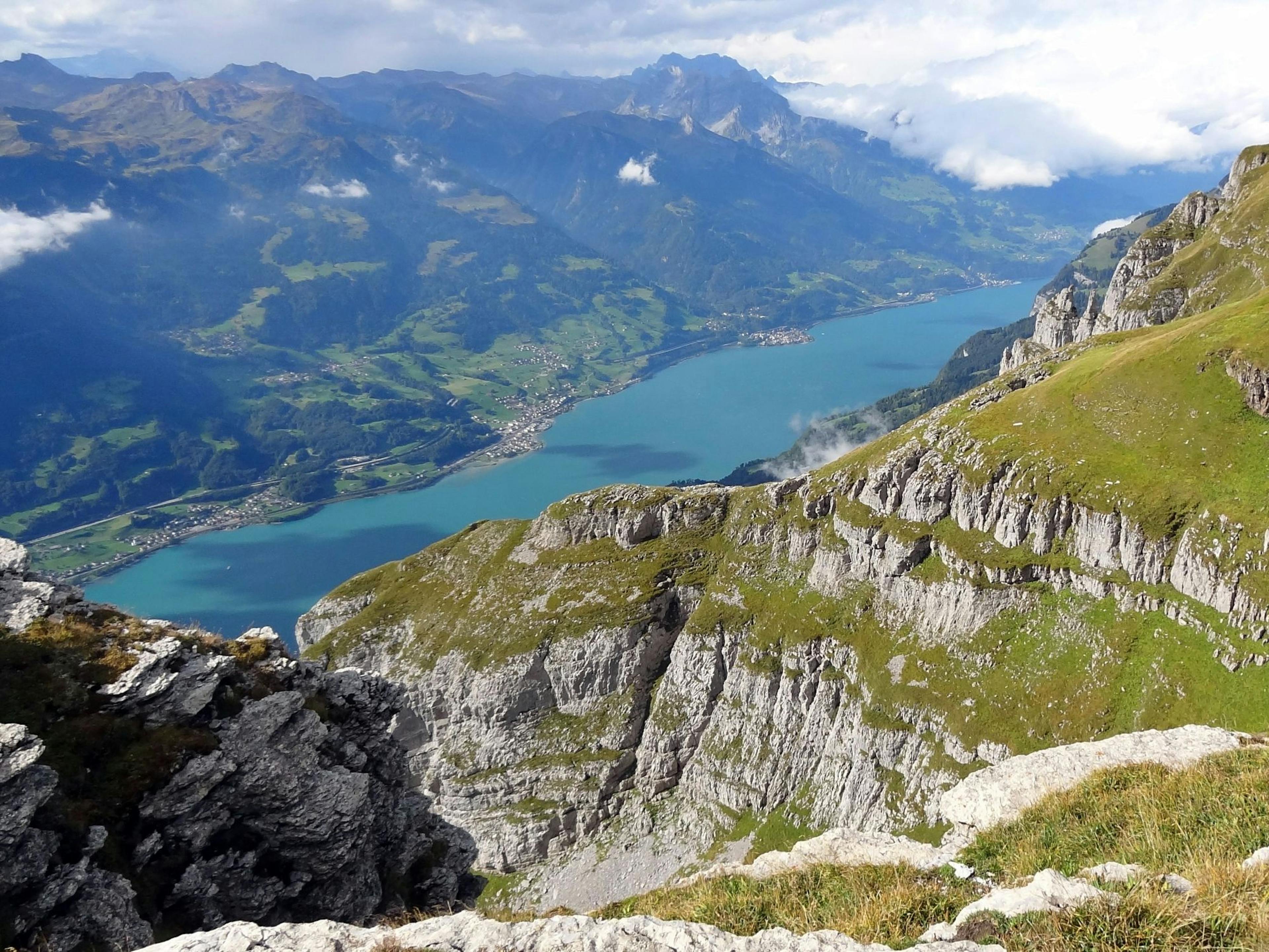 Caminhada no Walensee, vista para o lago, montanhas ao redor, campos verdes.