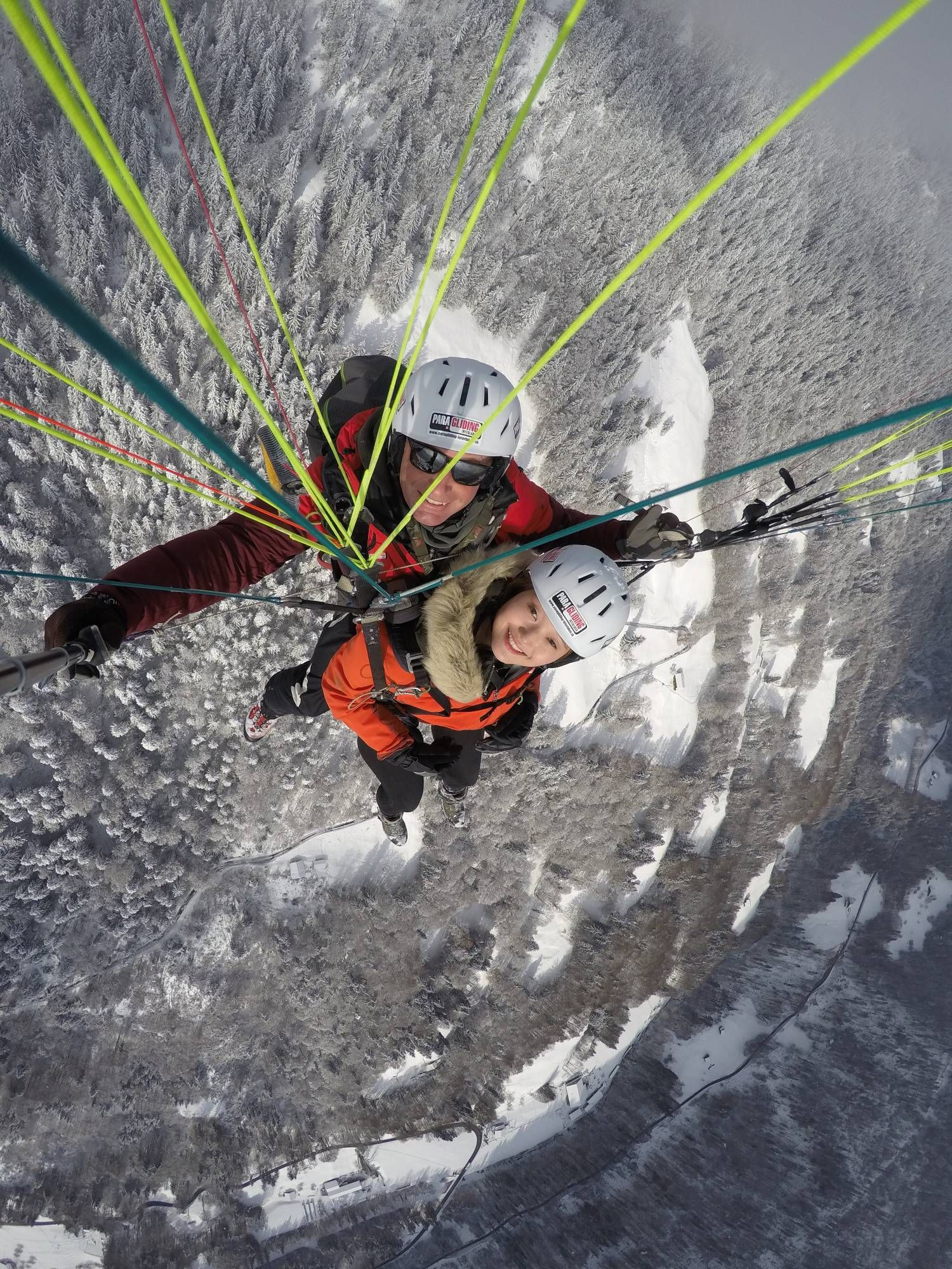 Tandem fallskärmshopp i Interlaken, vinterlandskap med snö, två personer i hjälmar