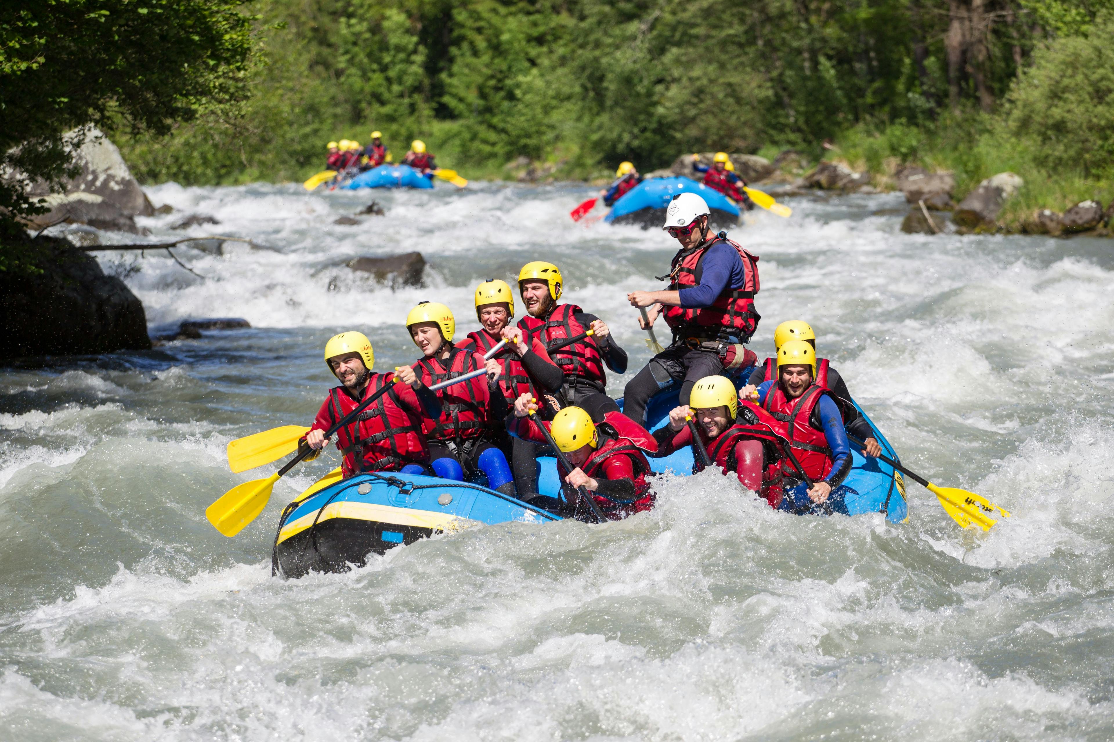 River Rafting Vispa mit abenteuerlustigen Personen in wilder Strömung.