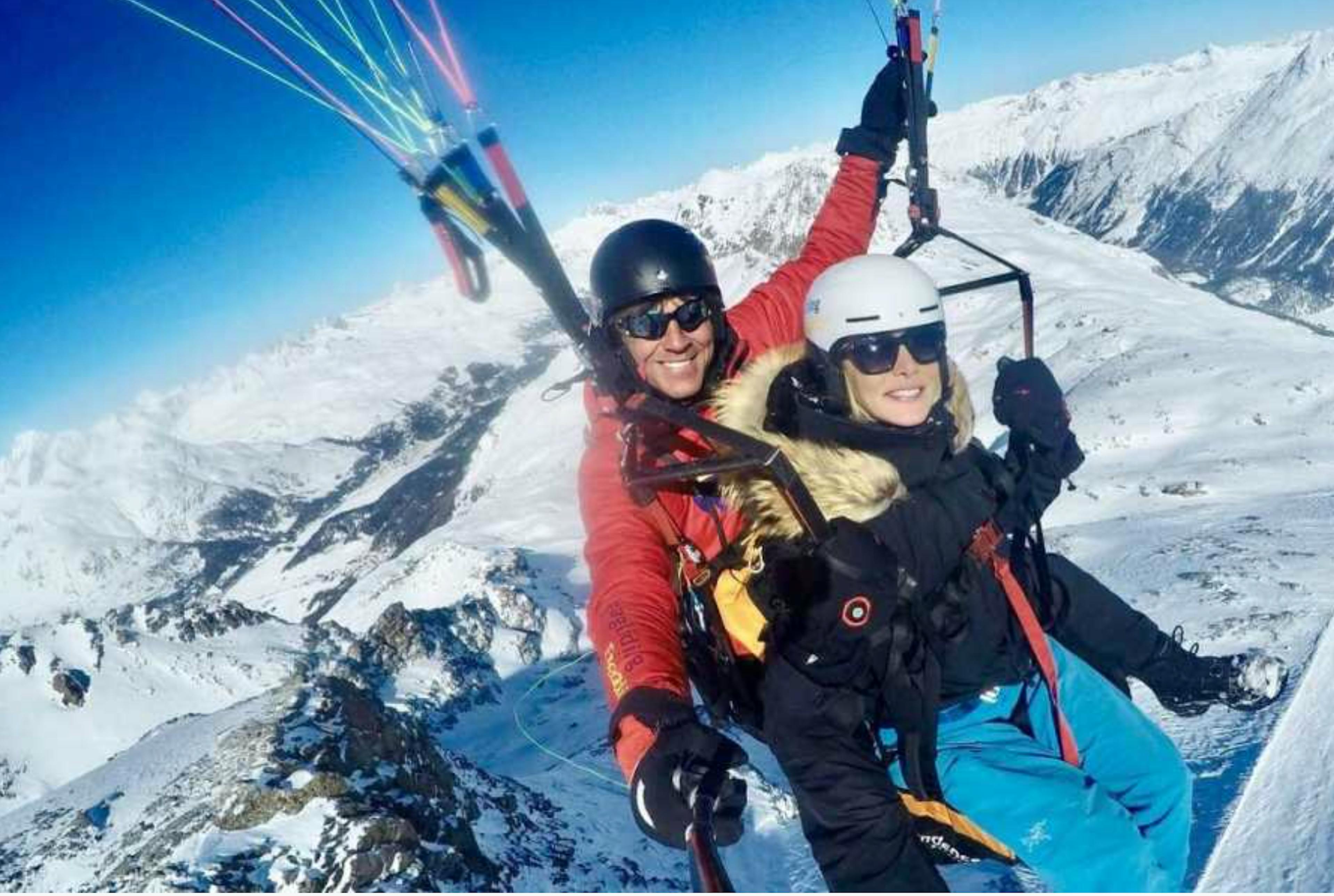 Voo tandem de inverno no Engadin com parapente e montanhas cobertas de neve.