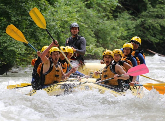 Rafting Simme bersama kelompok petualang dengan helm kuning dan rompi pelampung di arus deras