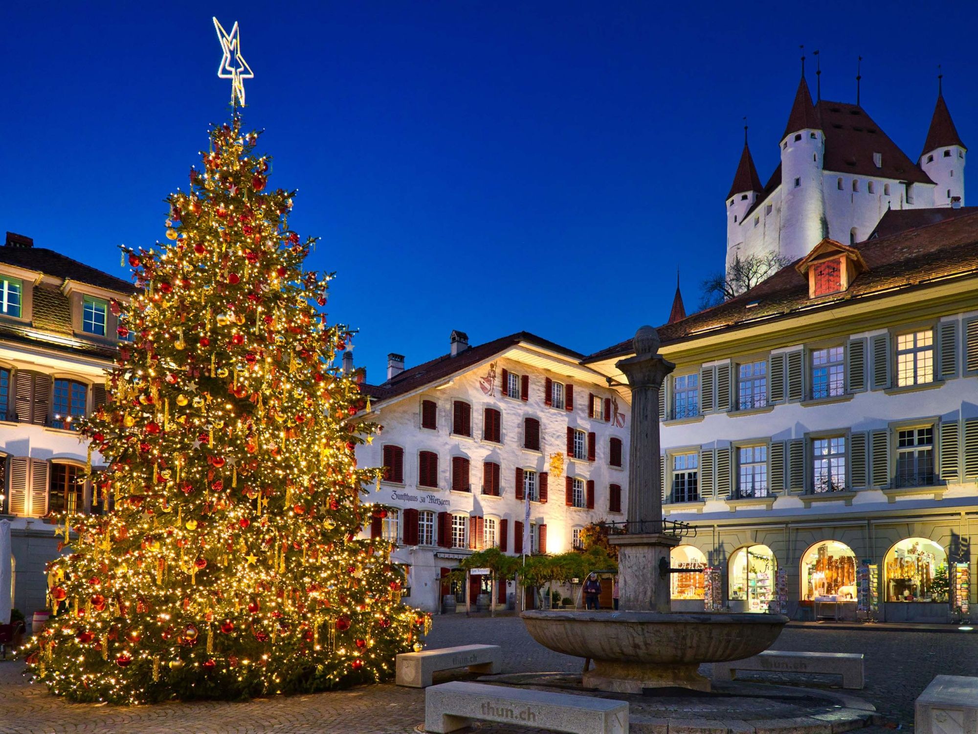 Place du Rathaus à Thun avec un magnifique sapin de Noël, éclat lumineux et ambiance hivernale.
