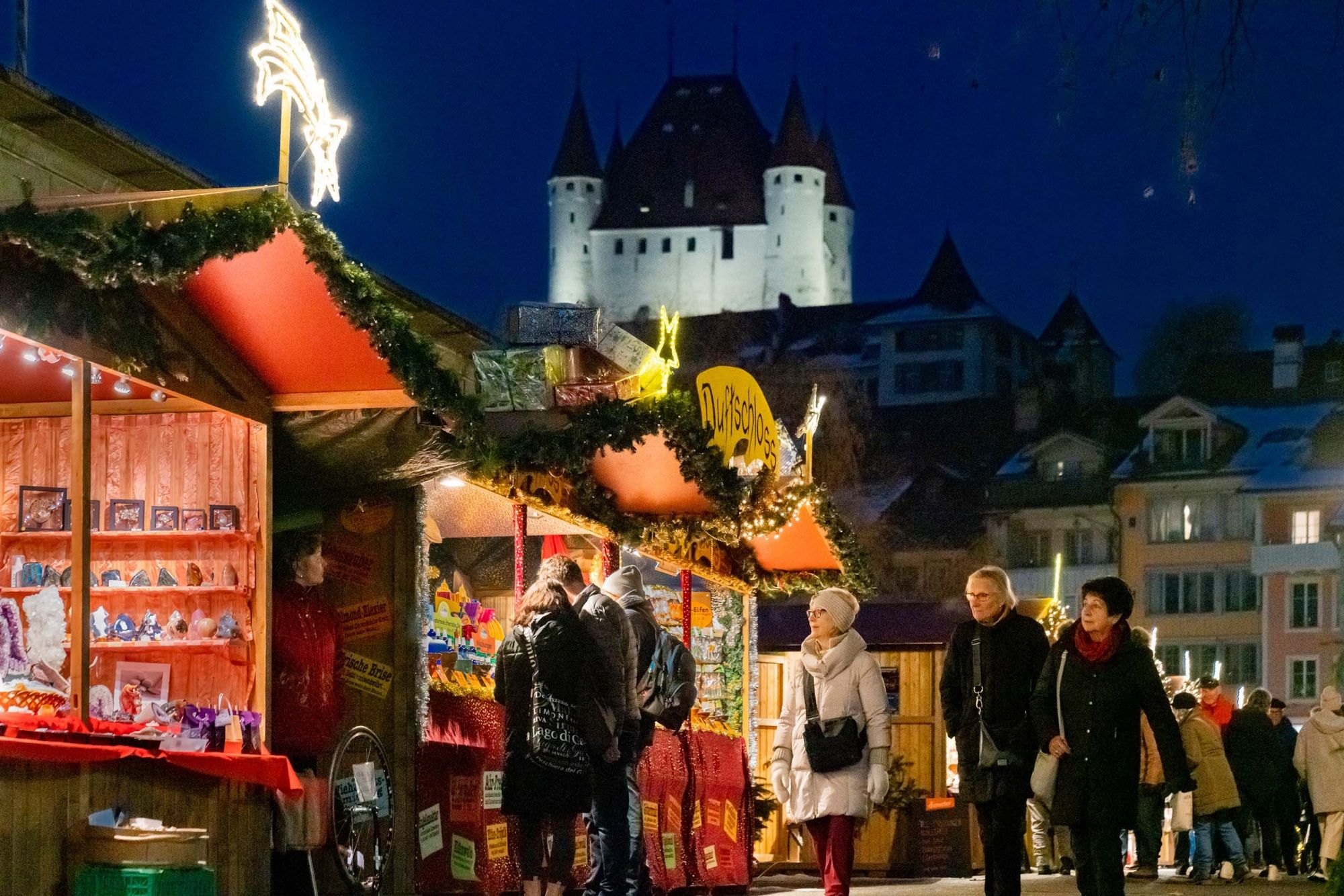 Marché de Noël de Thun avec des stands et des visiteurs, ambiance festive sur la Muehliplatz en hiver