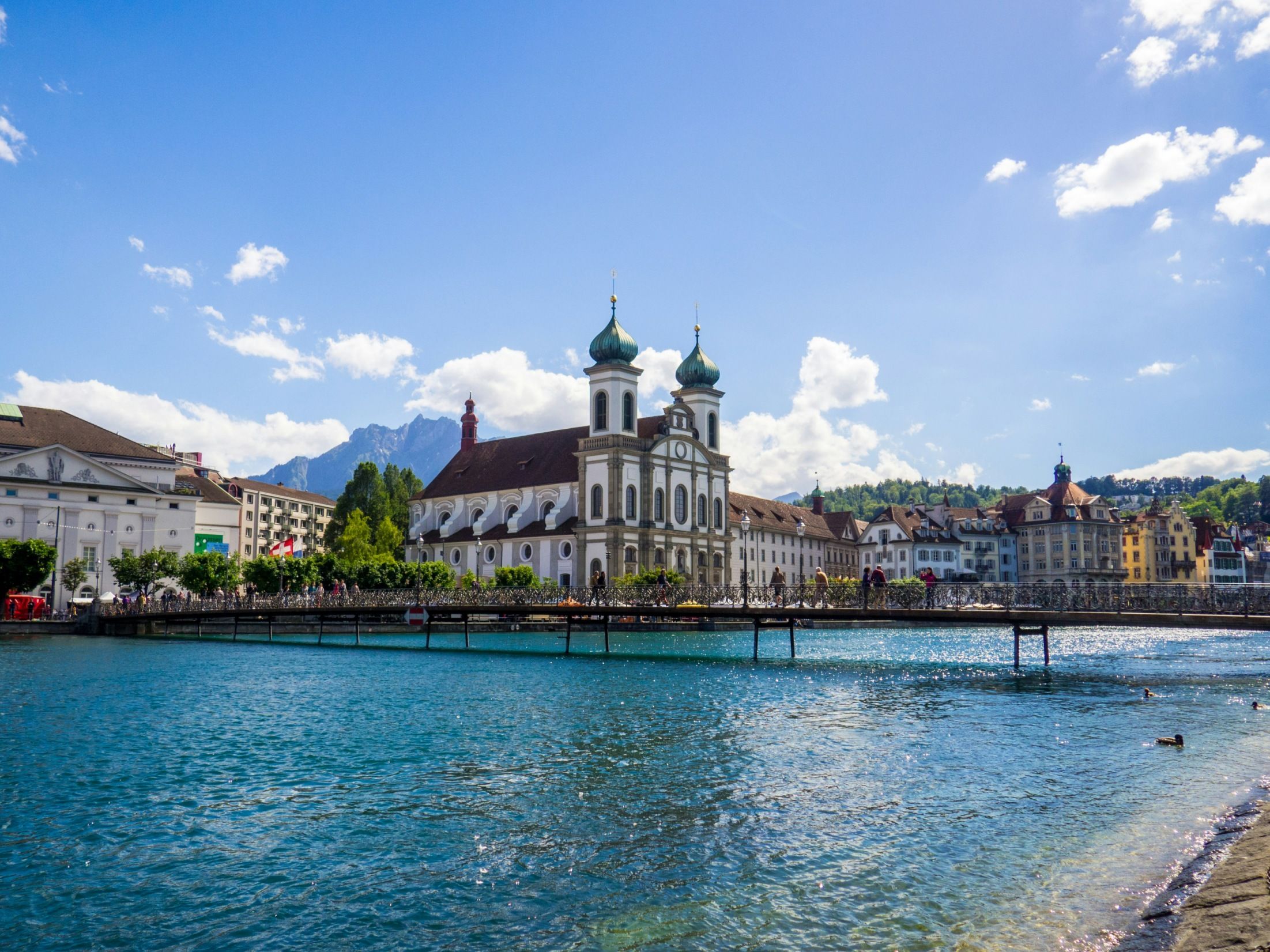 Люцерн: красивый городской вид с водою и историческими зданиями на заднем плане