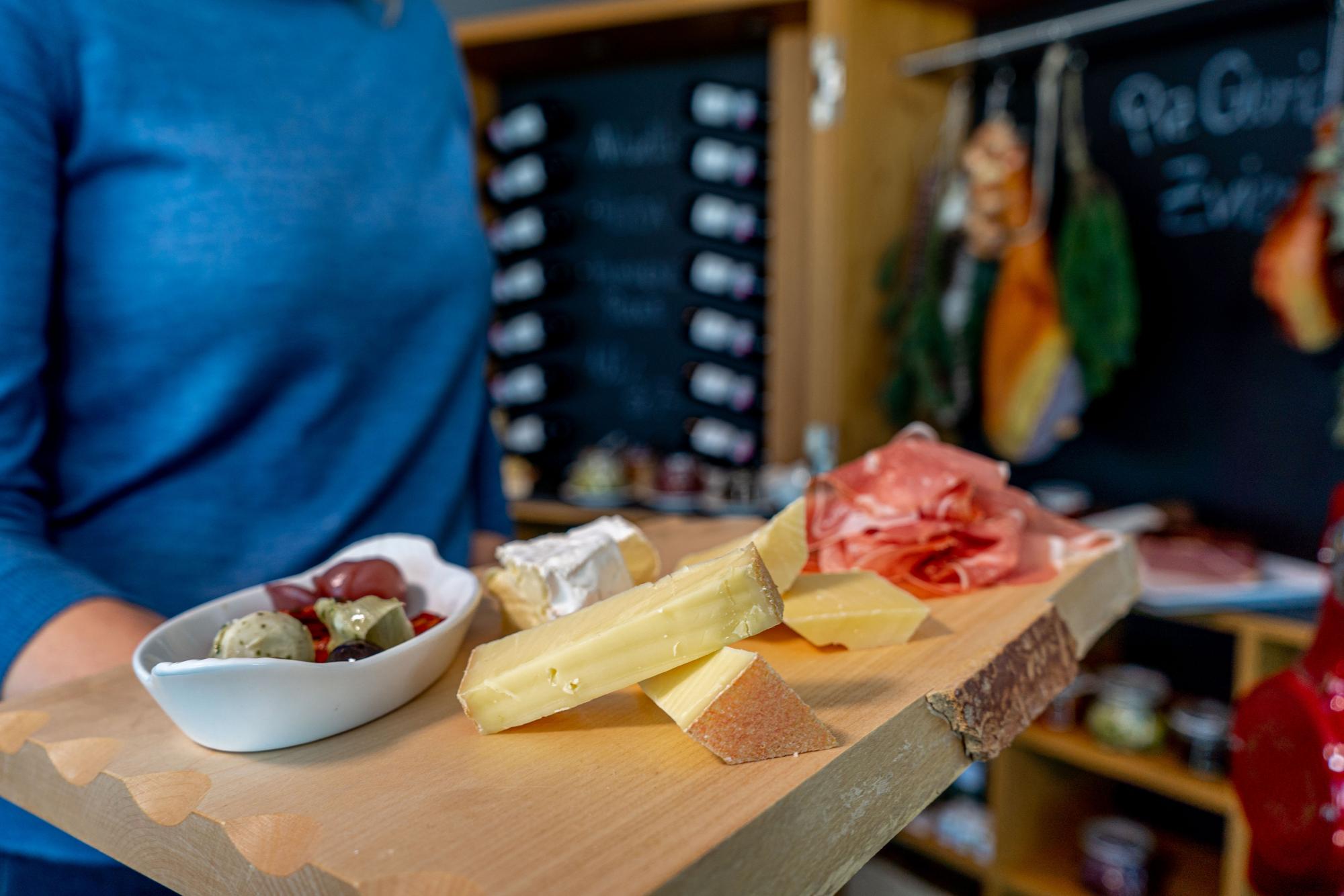 Zvieri Piz Gloria con queso, salchichas y aperitivos en bandeja de madera.